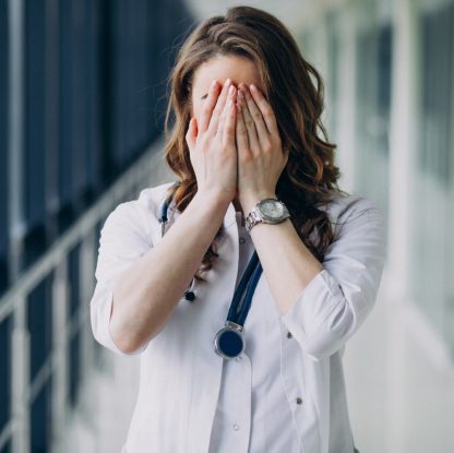 lekarka zakrywająca oczy rękami