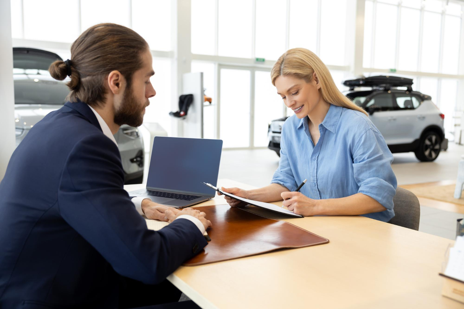 kobieta podpisująca umowę w salonie samochodowym