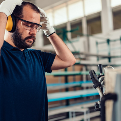 pracownik w słuchawkach wygłuszających